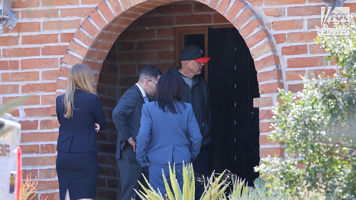 Investigators standing at the entrance of Nancy Guthrie's home in Tucson, Arizona