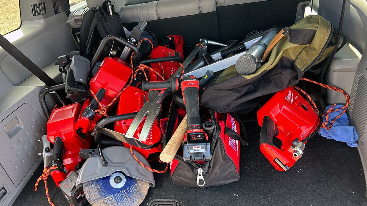 Power tools are picture in a car's trunk.