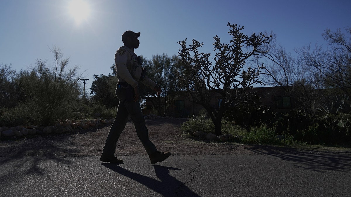 A member of the Pima County Sheriff's office standing on Nancy Guthrie's street.