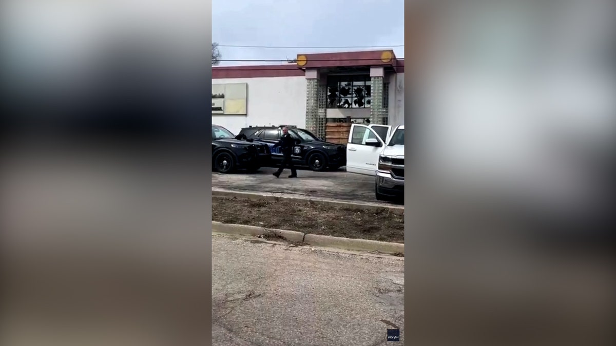 police approach patrol vehicle