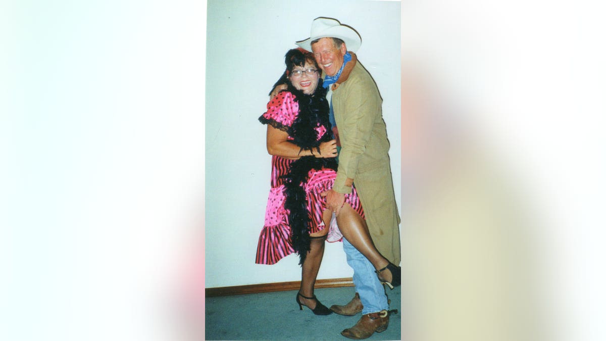 Deb Proctor and Jeff Walton in costume smiling and holding each other.
