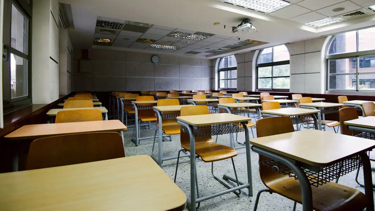 An empty classroom with rows of desks and chairs
