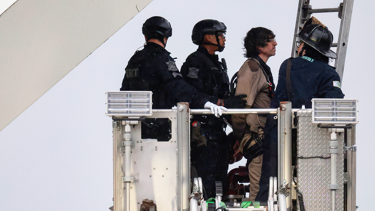 Protester Guido Reichstadter comes down from atop the Frederick Douglass Memorial Bridge