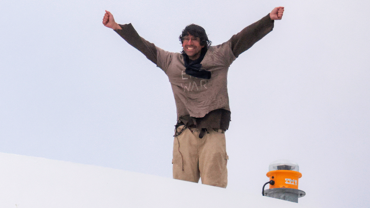 Protester Guido Reichstadter stands atop the Frederick Douglass Memorial Bridge