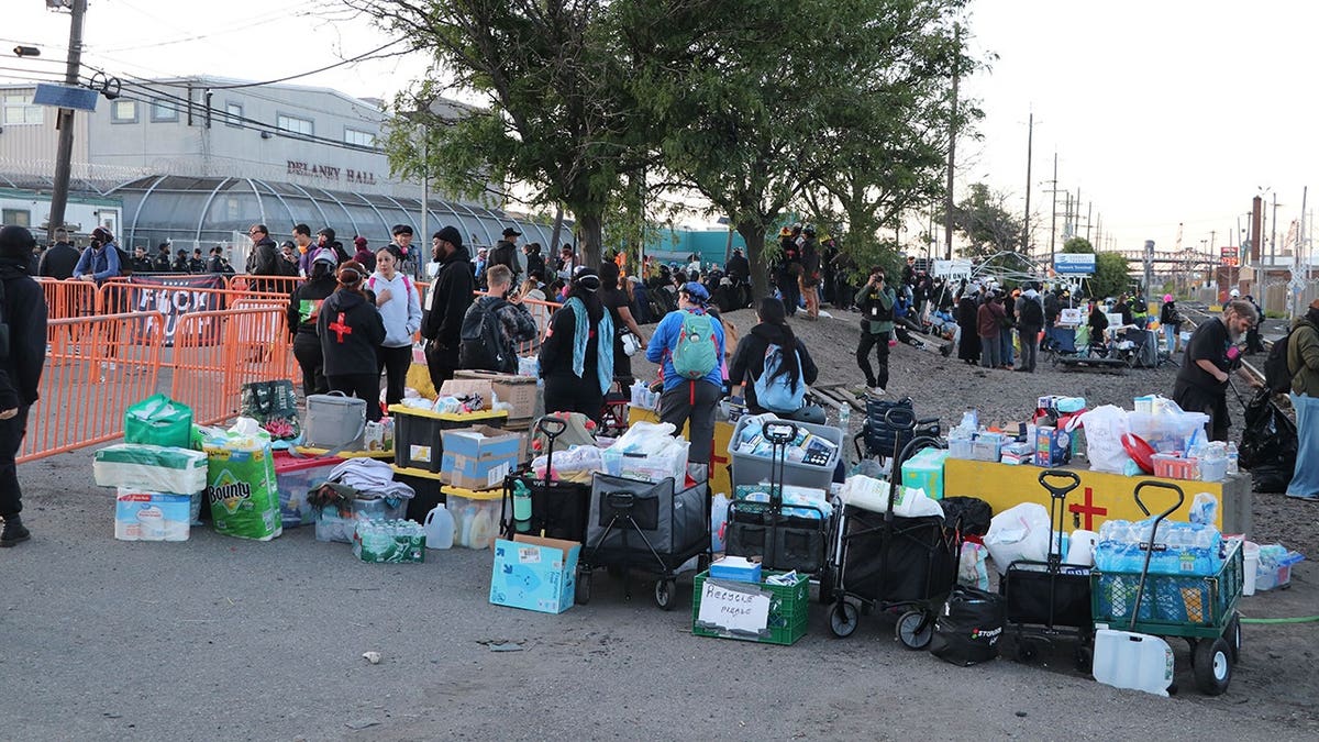 protesters near tables and bins of supplies