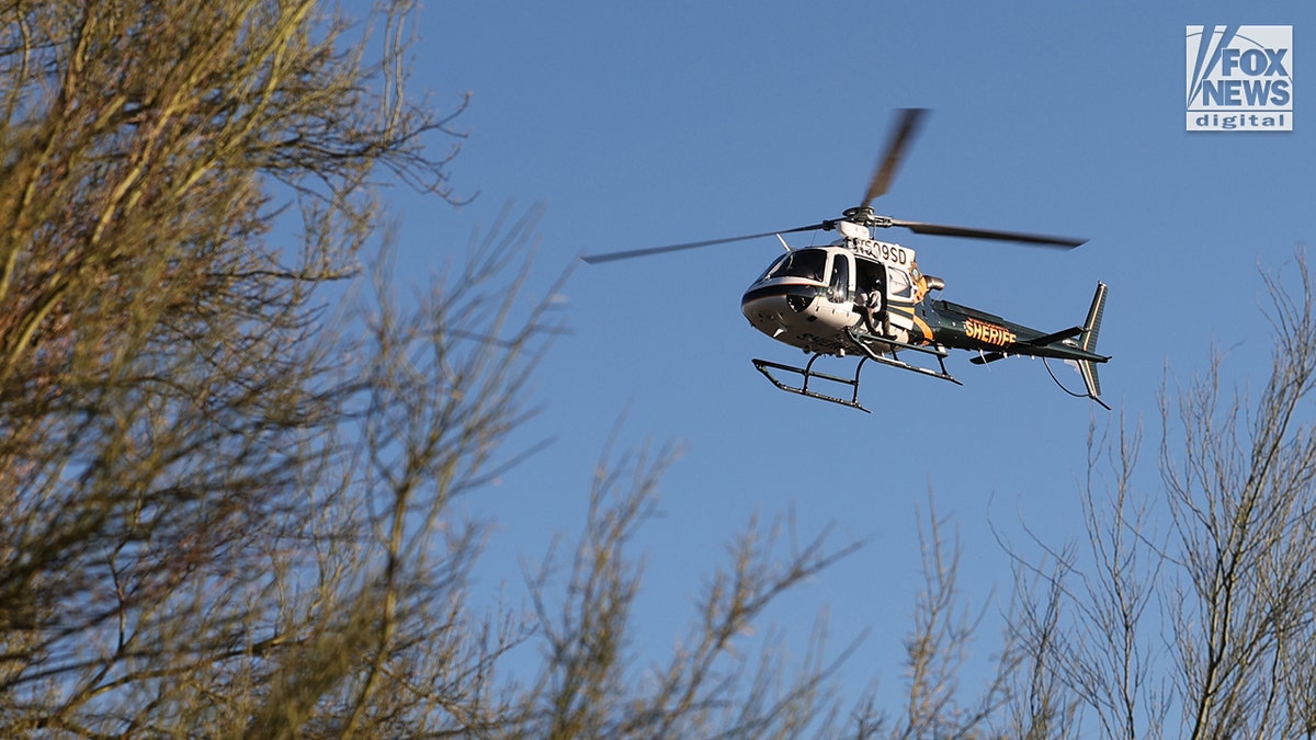 Pima County Sheriff helicopter flying over desert in Tucson searching for Nancy Guthrie