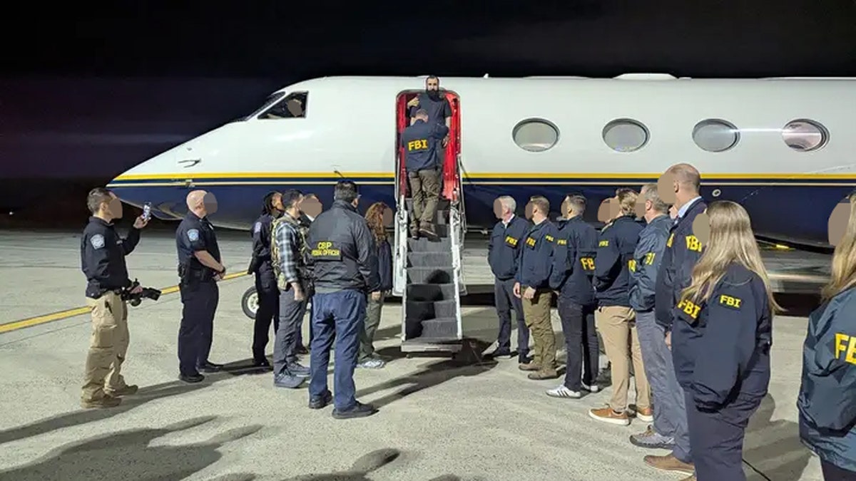 Iraqi suspect led off of government plane by FBI officers