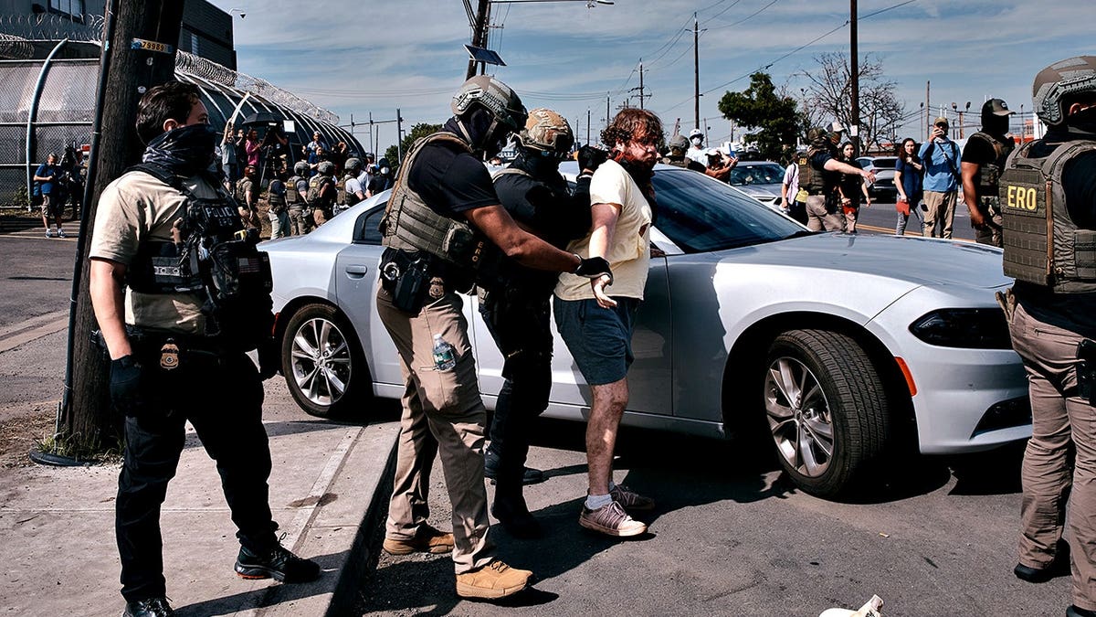 ICE agents detaining a protestor outside Delaney Hall detention center in Newark