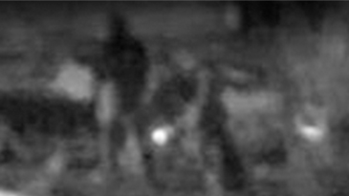 Grainy surveillance image appearing to show individuals outside a federal ICE facility in Arizona at night.