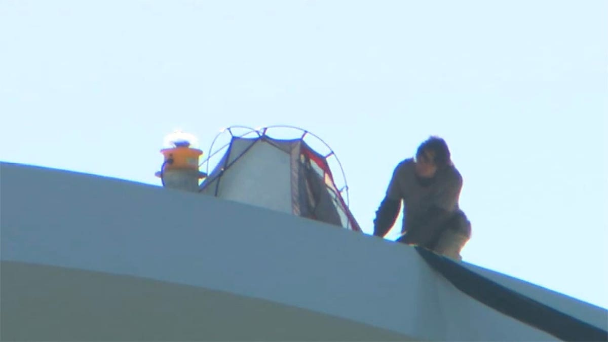 Man next to a tent on a bridge