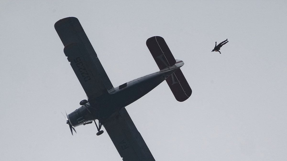Parachutist Dmitri Lovetsky jumping from Antonov AN-2 biplane at airfield