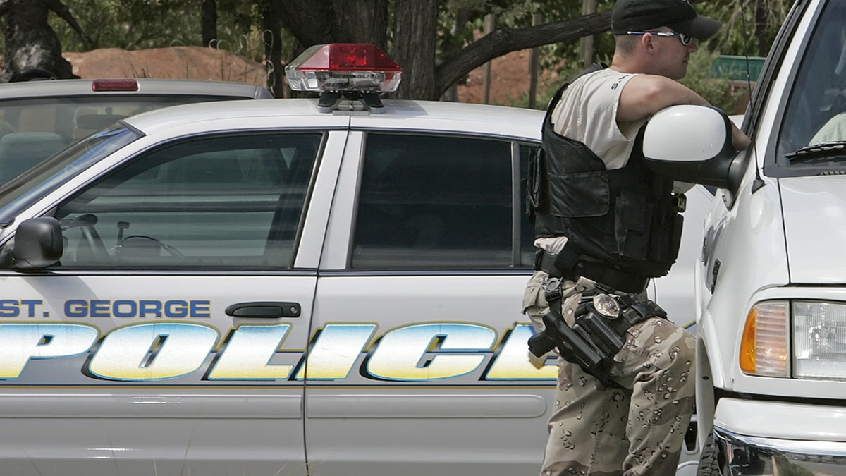 A St. George police officer stands outside his patrol car