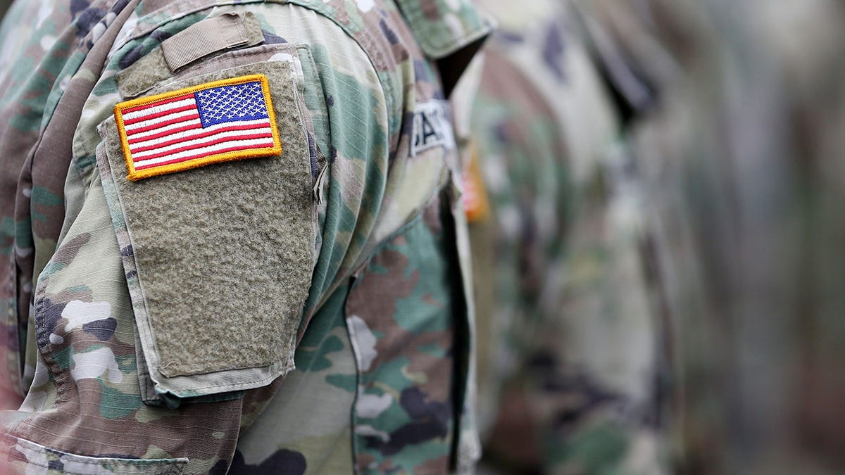 Members of the United States Military standing on the track at Charlotte Motor Speedway