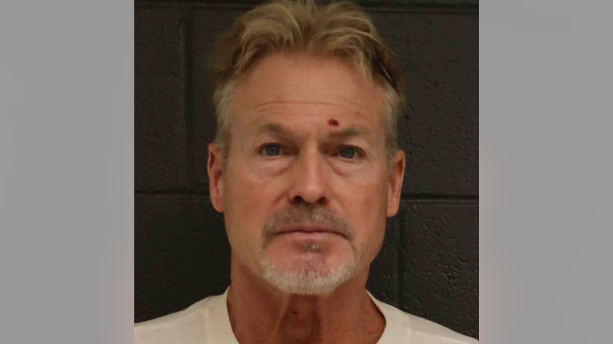 Barry Morphew standing for booking photo at Alamosa County Jail