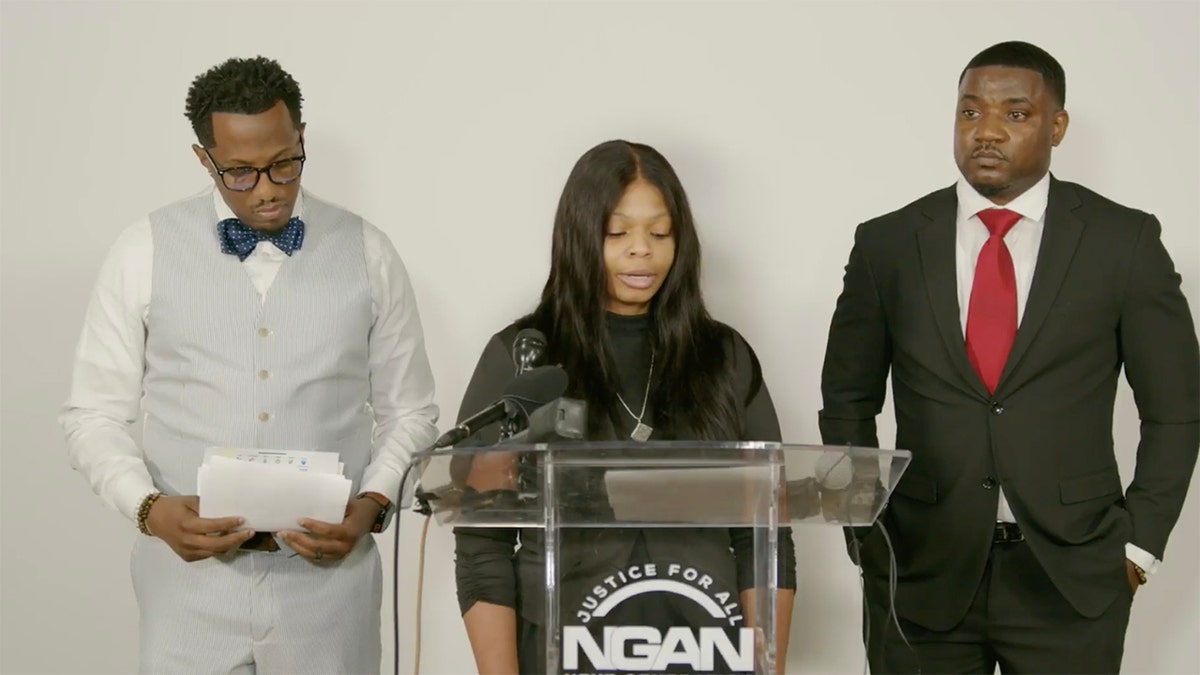Kayla Hayes speaking at a press conference indoors.