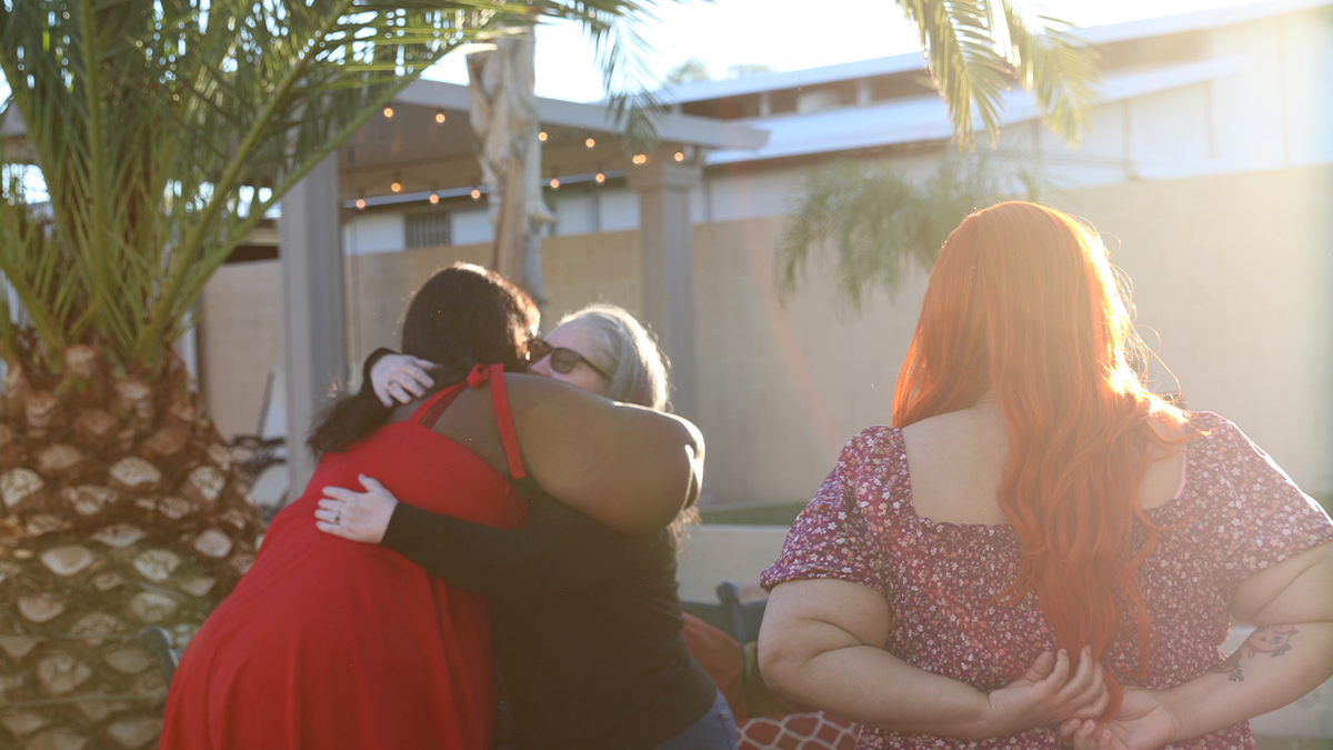 Members of the Pearadise community embrace outside the Las Vegas house featured in the documentary