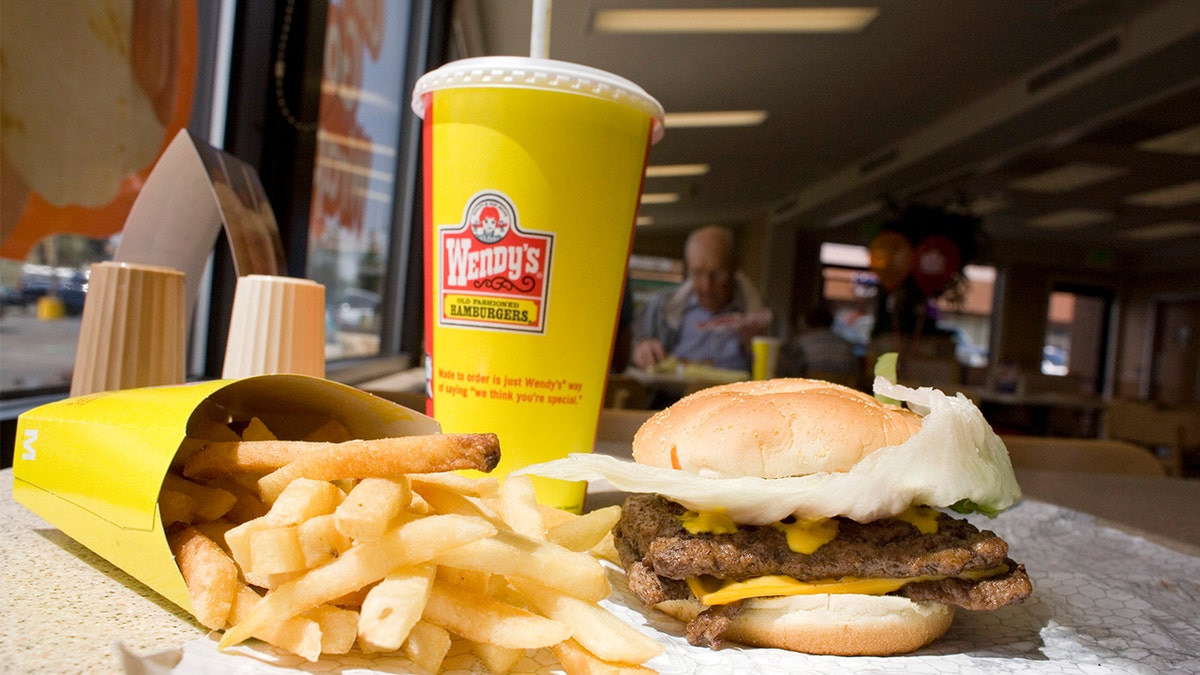 Wendy Thomas sitting at a table with a Wendy's meal close-up