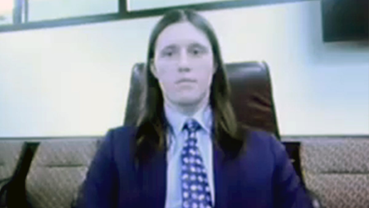 Lance Twiggs wearing a blue suit with shoulder length hair