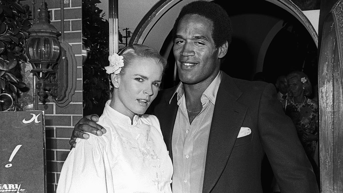 Nicole Brown and OJ Simpson stand together.