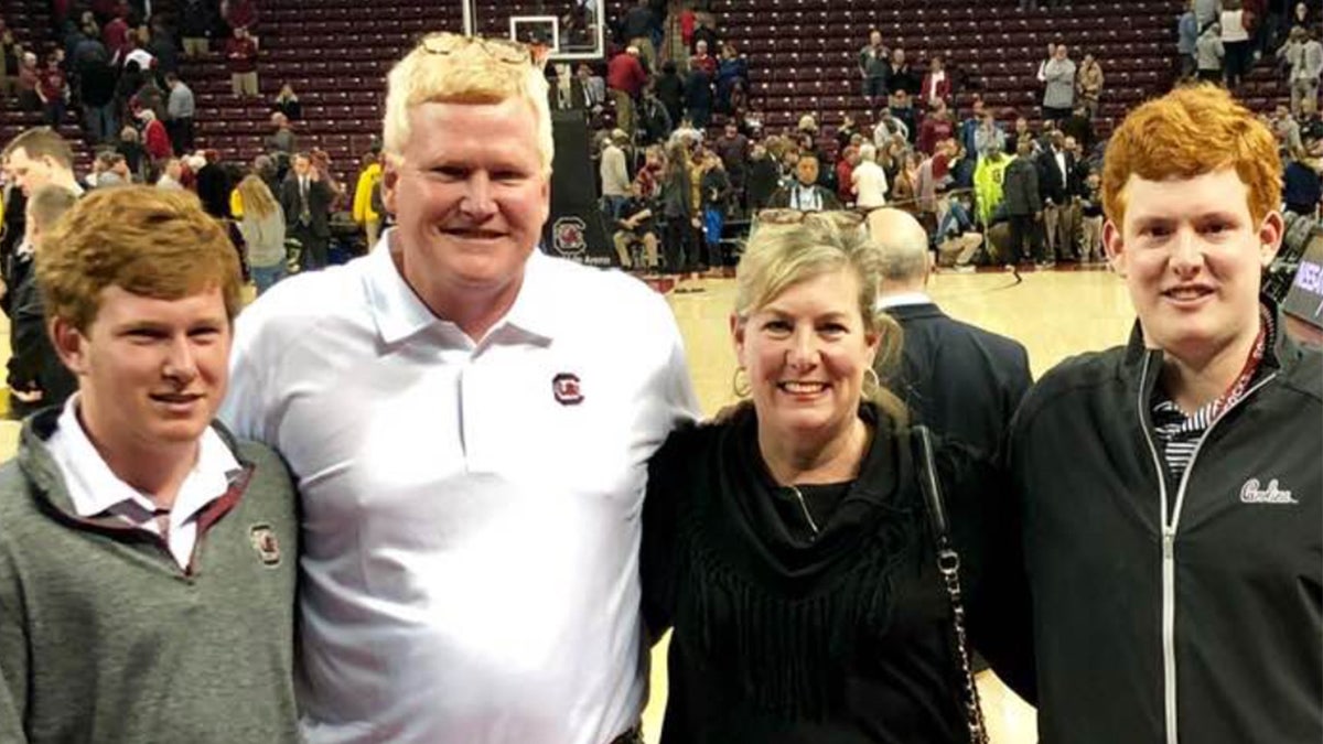 Paul, Alex, Maggie and Buster smile at a basketball game.