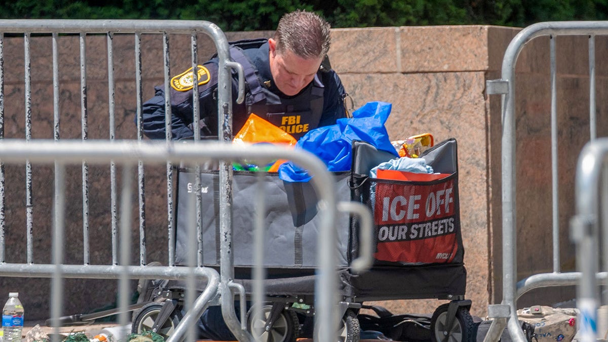 A federal officer investigates the scene after an incendiary device went off outside 26 Federal Plaza in Lower Manhattan early on Monday in New York City.