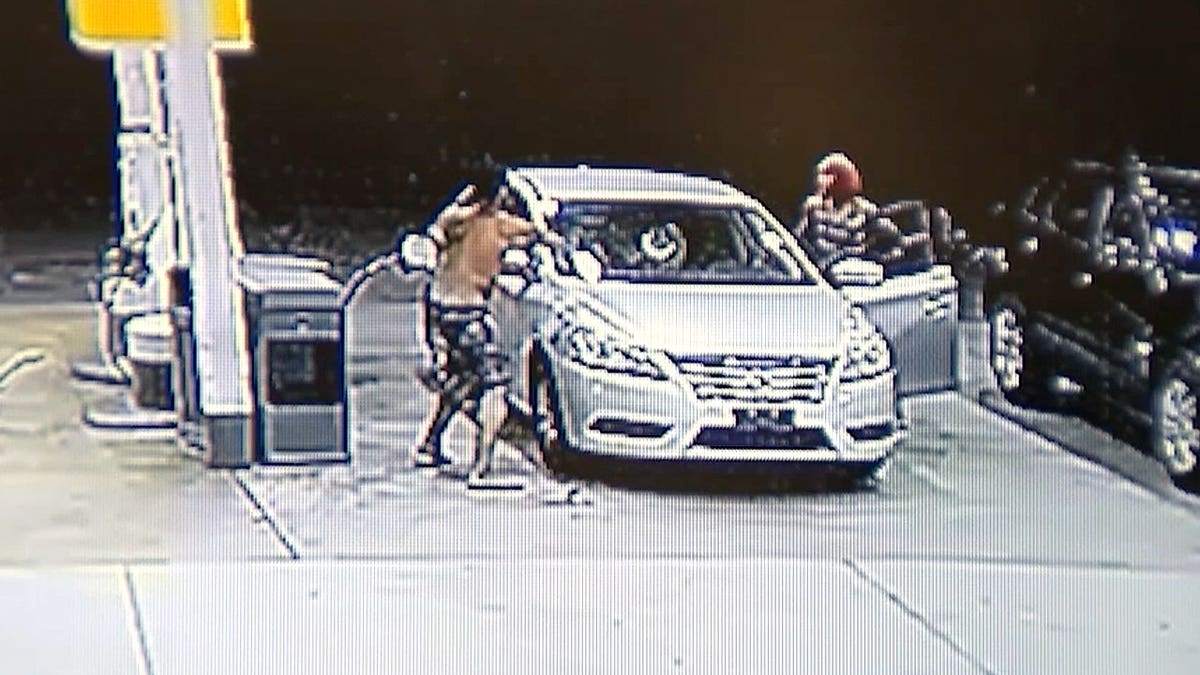 Surveillance video shows a man reaching into a family's vehicle as the children's mother confronts him at a Georgia gas station.