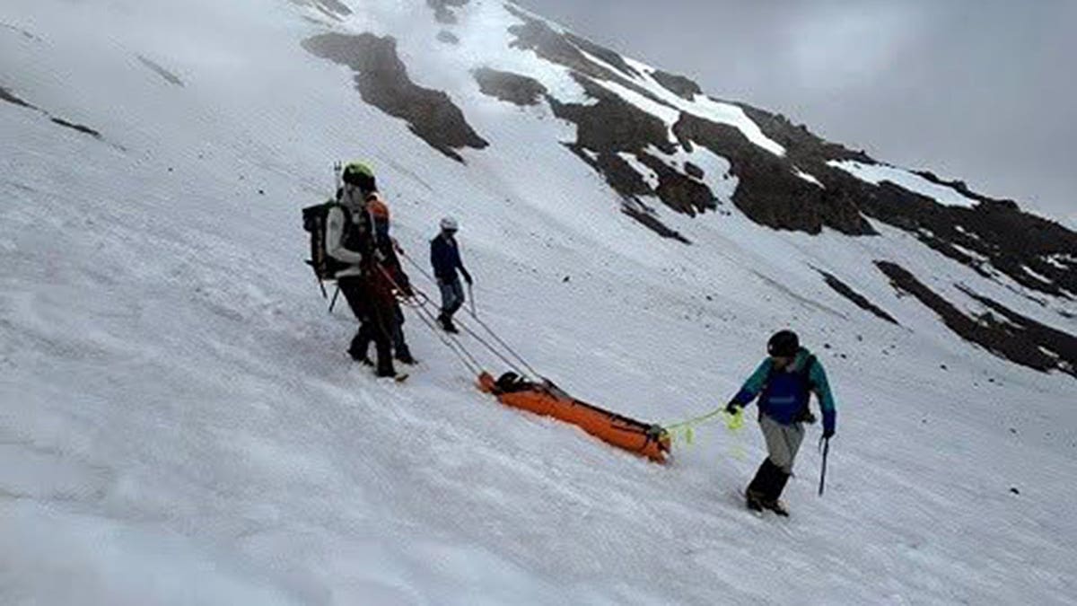 Climbing rangers lower injured Mount Shasta climber on rescue litter
