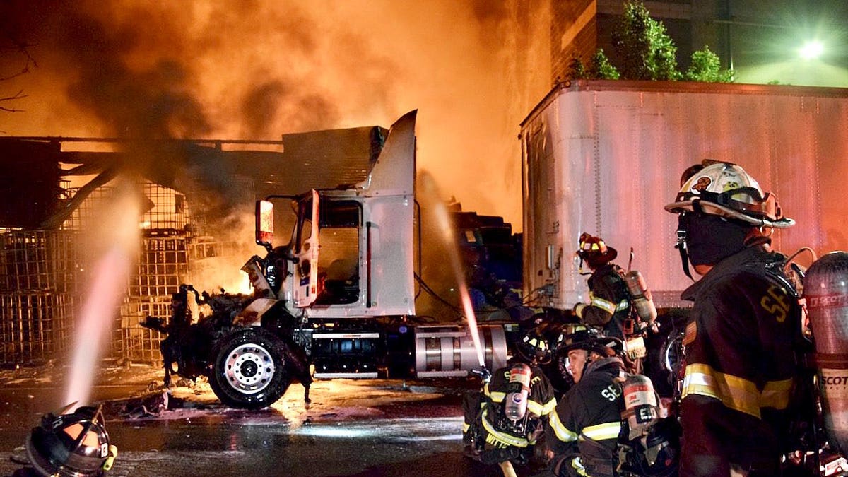 Firefighters spraying water on a fire