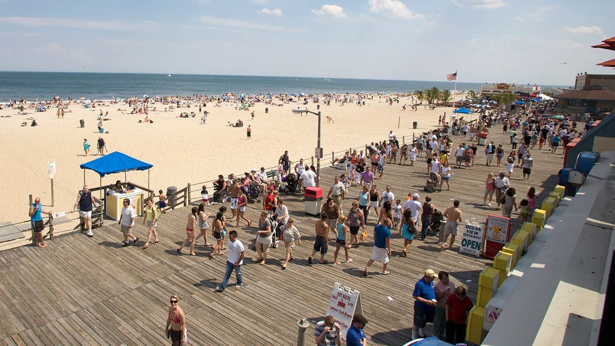 photo shows boardwalk with people and the beach nearby
