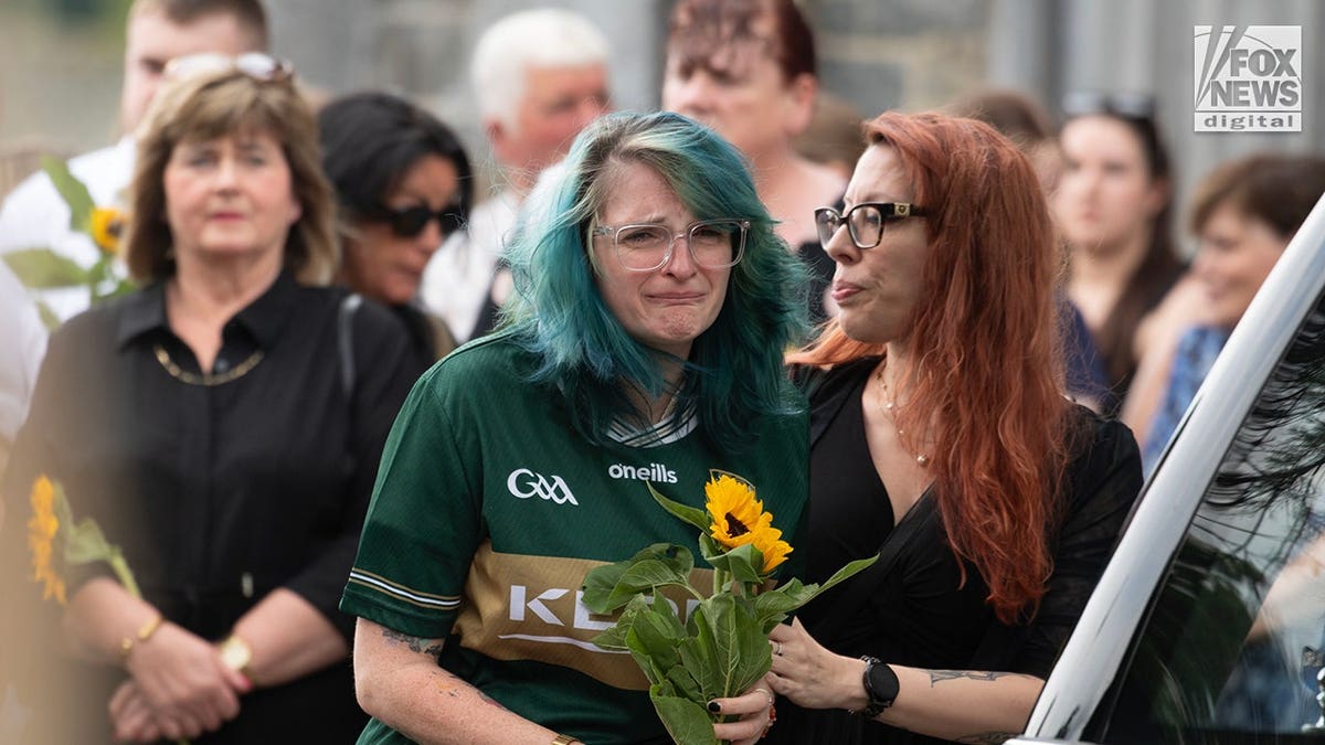 Devon is consoled at a funeral inside St. Mary's Cathedral in Killarney, Ireland.