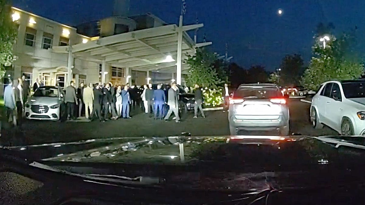 Dashcam footage shows a large crowd of wedding guests gathered outside an Ohio banquet hall as police arrive.