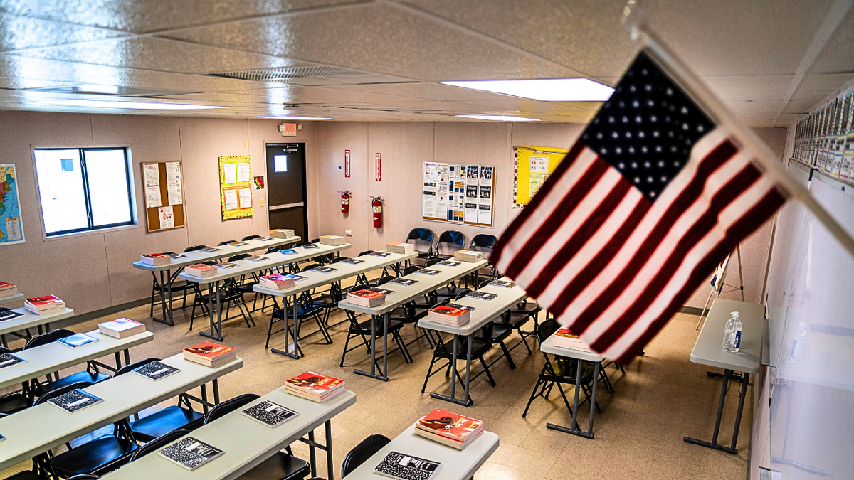 Text books and notebooks line tables inside a classroom at a Influx Care Facility in Carrizo Springs, TX.