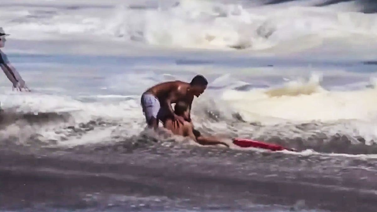 Witnesses say the dramatic rescue lasted far longer than the viral video shows, with the teen lifeguard refusing to release the child despite punishing surf.