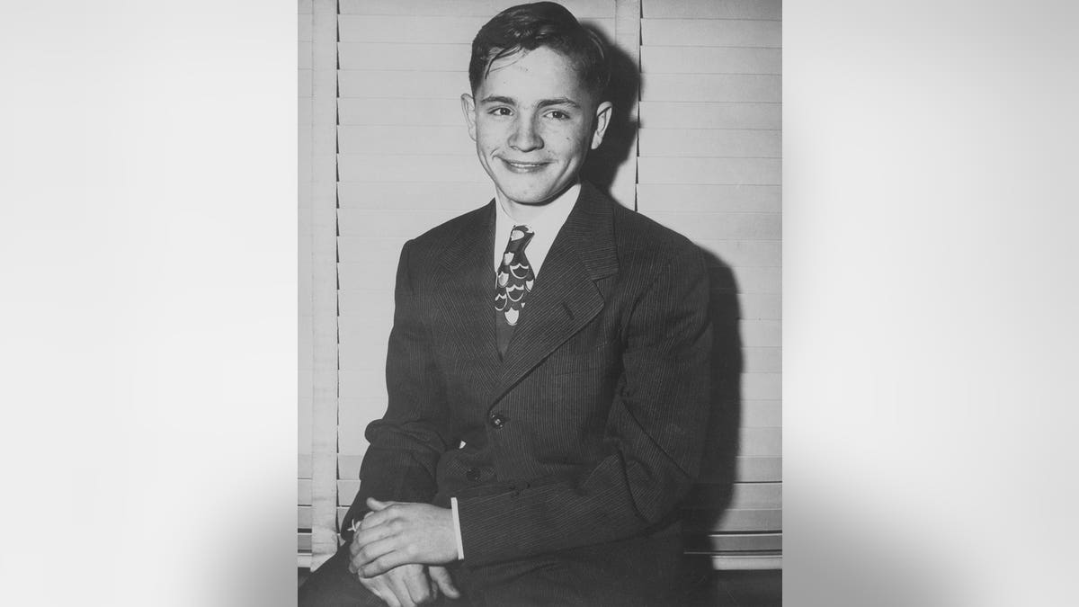 Charles Manson poses in a suit and tie.