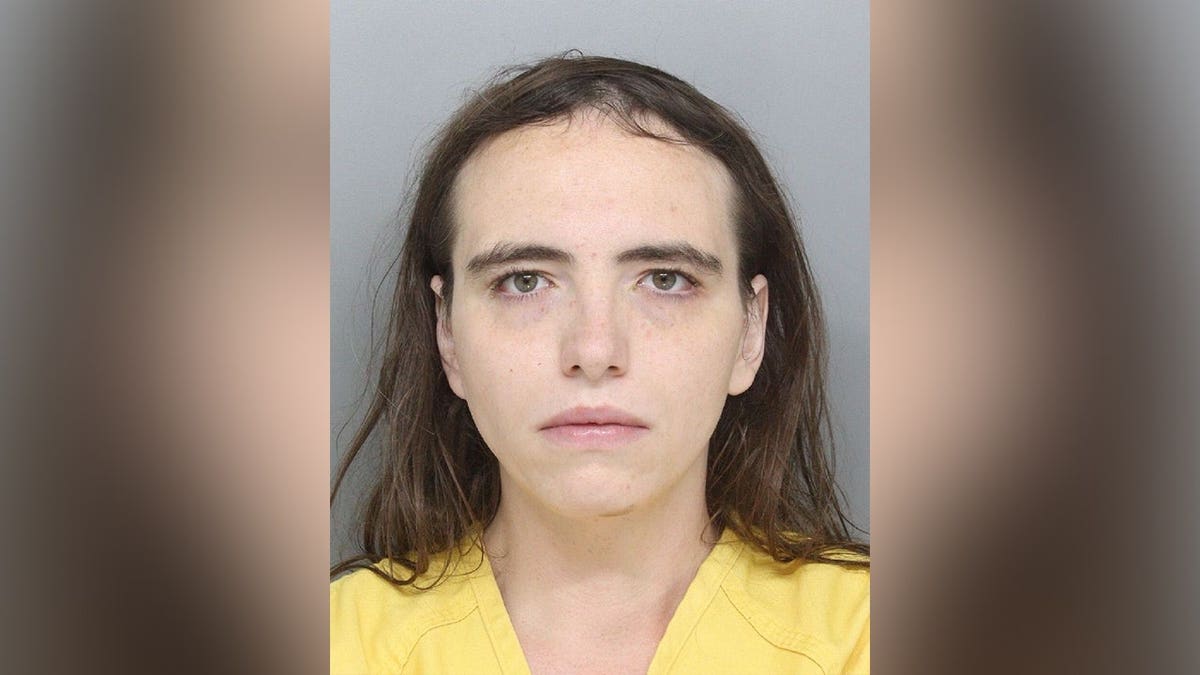 Booking photo of Kirby Rankin wearing a yellow jail uniform against a gray background.