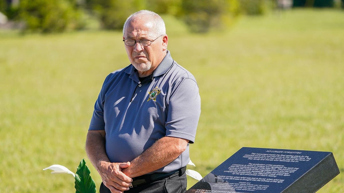Hamilton County Coroner Jeff Jellison stands during memorial services for Fox Hollow Farm victims.
