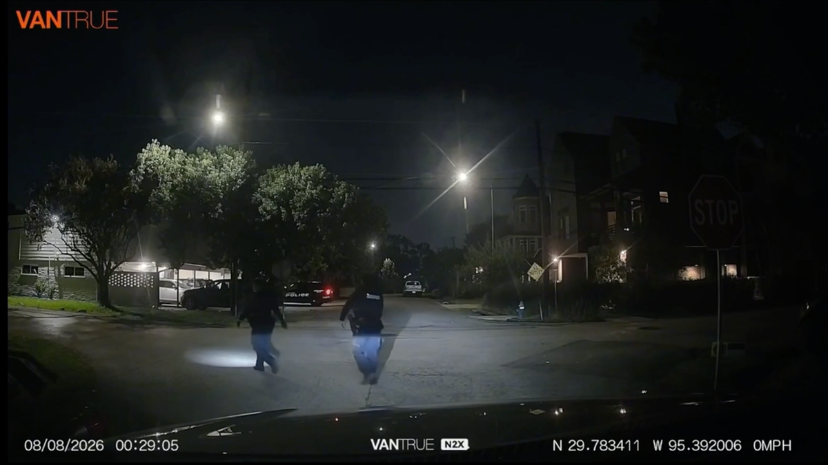Two Houston police officers run through a Houston Heights intersection during a nighttime foot pursuit seen in dashcam video