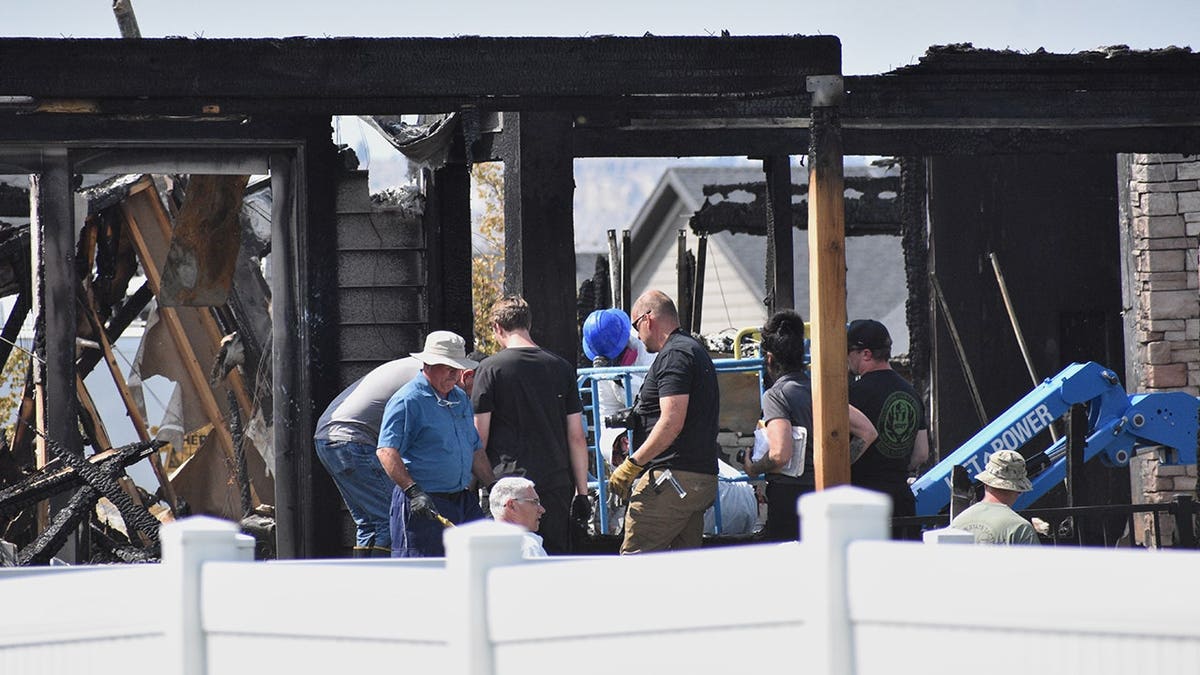 Investigators work at a burned house near Billings, Montana