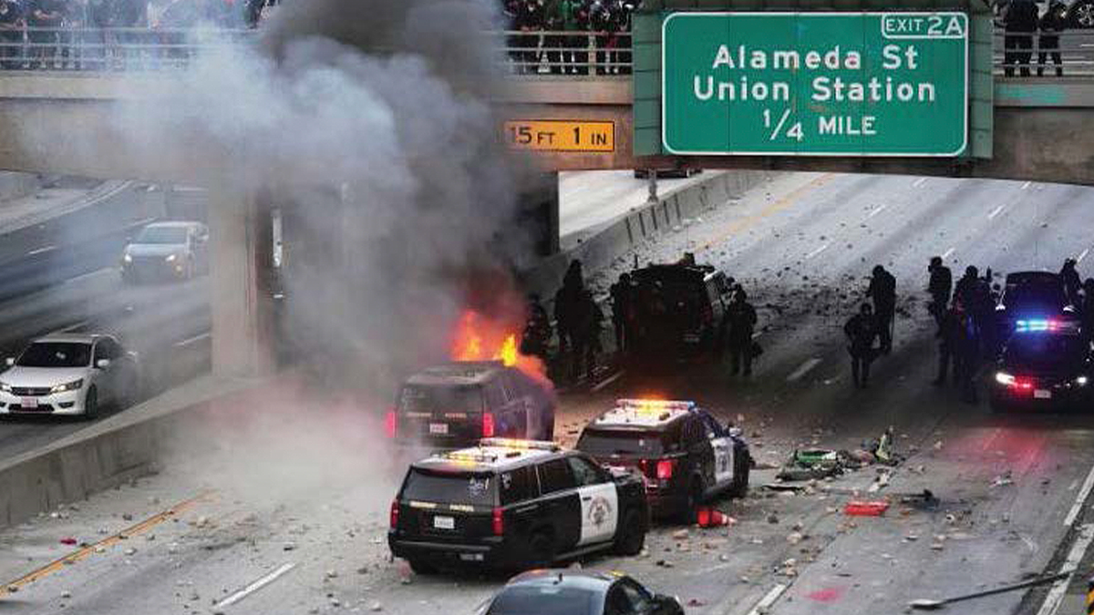 A California Highway Patrol vehicle burns beneath a Los Angeles freeway overpass during an anti-ICE riot as officers respond to the unrest
