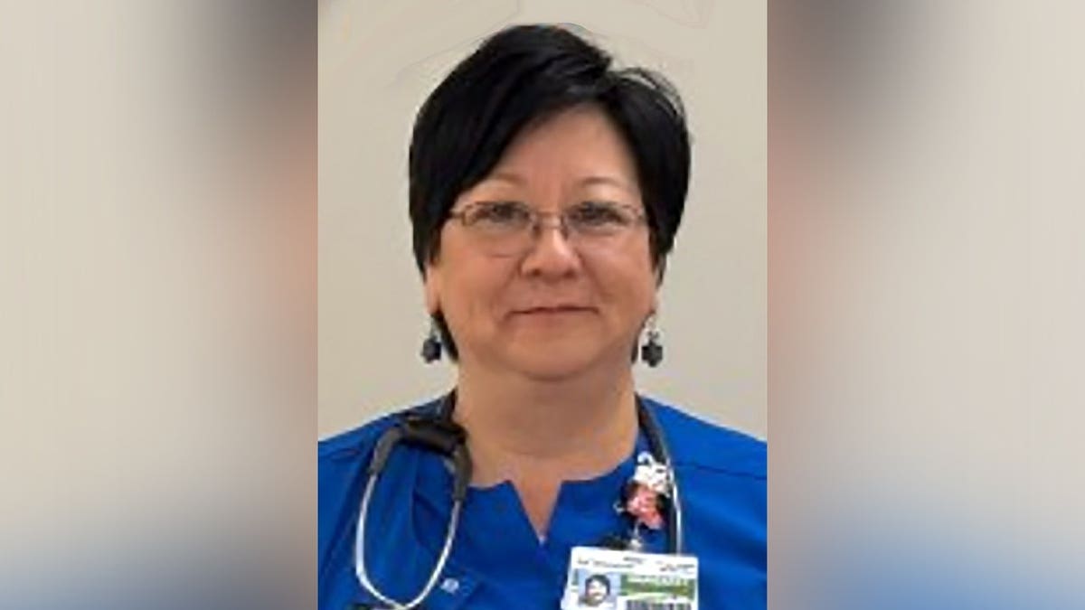 Margaret Chu Dufour poses for a photo in her nursing scrubs.