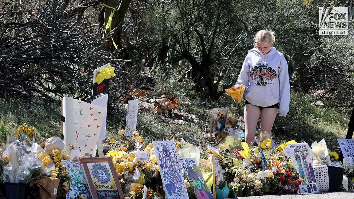 People carrying bouquets of flowers toward the front of a residence in Tucson.