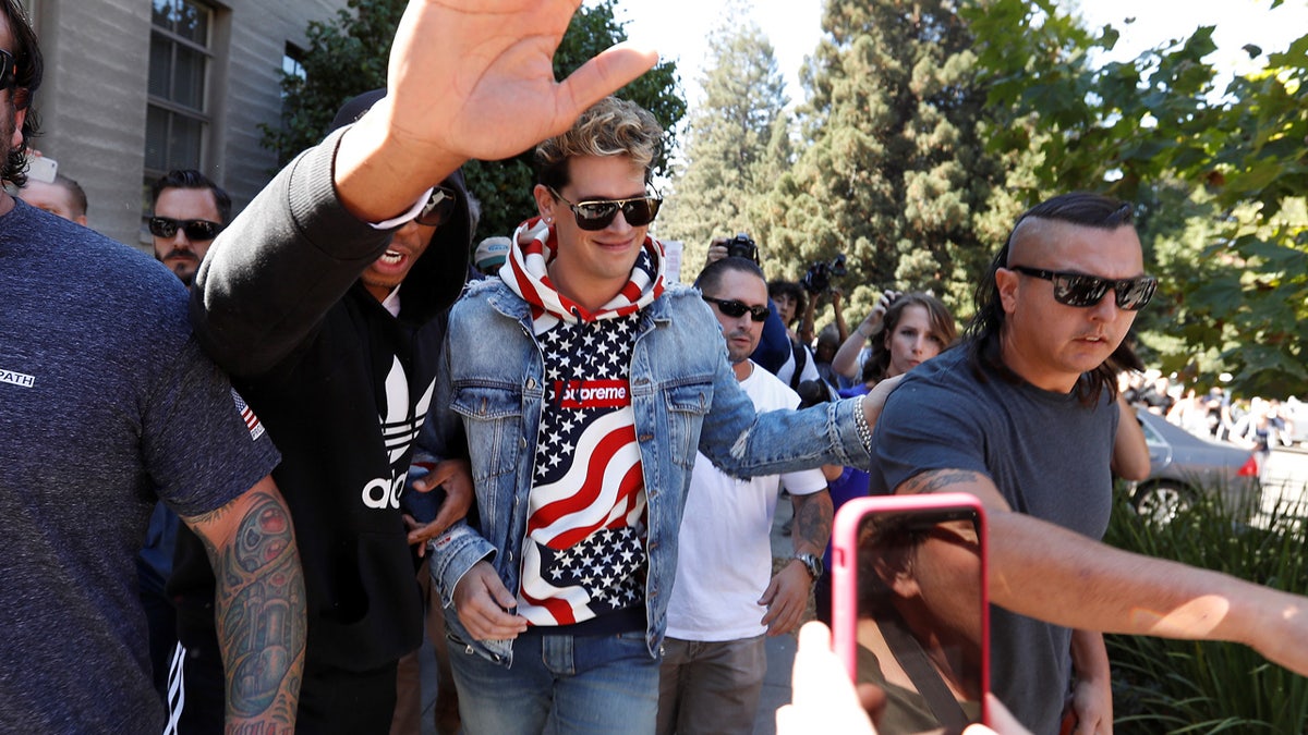Conservative commentator Milo Yiannopoulos walks while being escorted away after speaking at the University of California in Berkeley, California, U.S., September 24, 2017 REUTERS/Stephen Lam - RC12EC7FE520