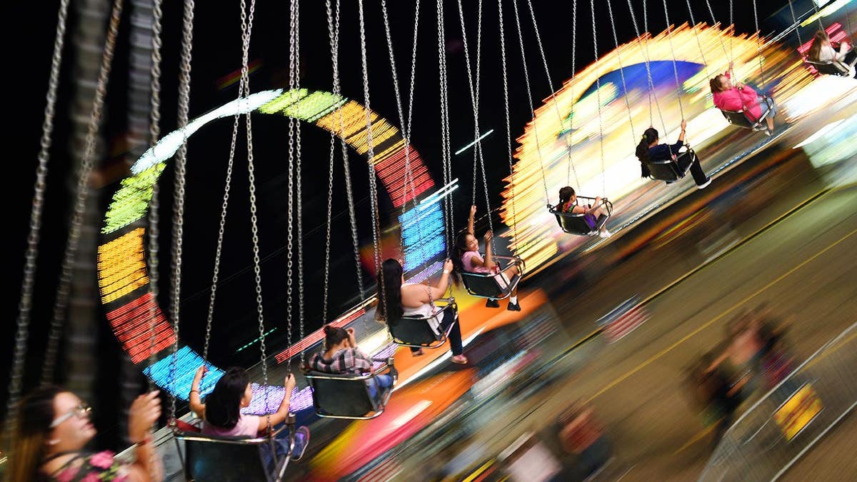 Carnival goers swing on the YoYo ride at the Colorado State Fair.