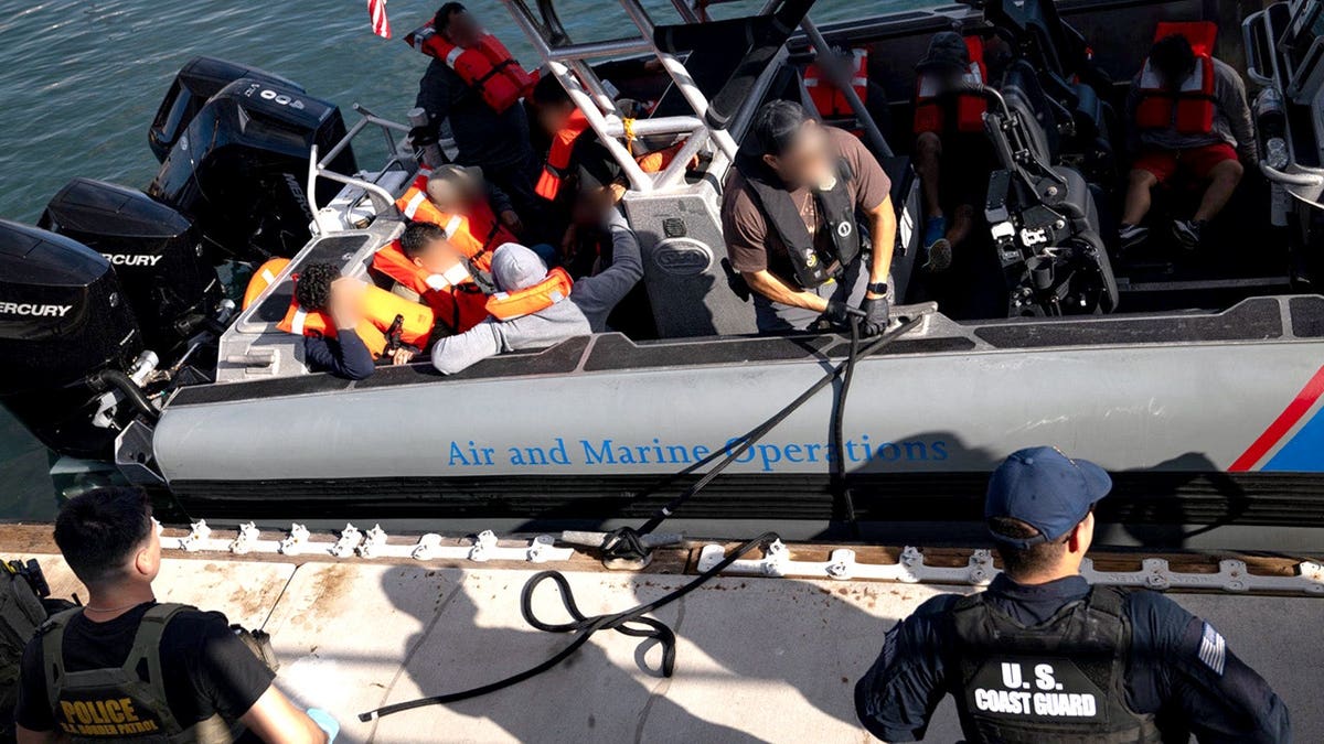 suspected migrants aboard Coast Guard vessel reaching shore