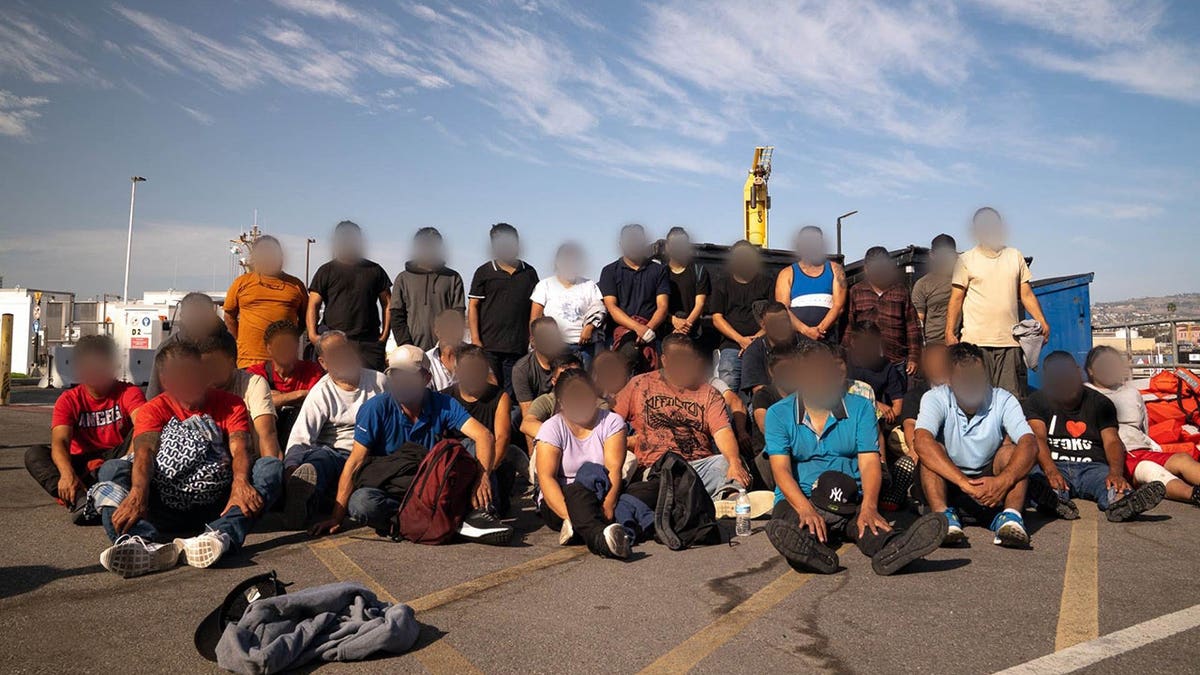 group of suspected migrants at dock