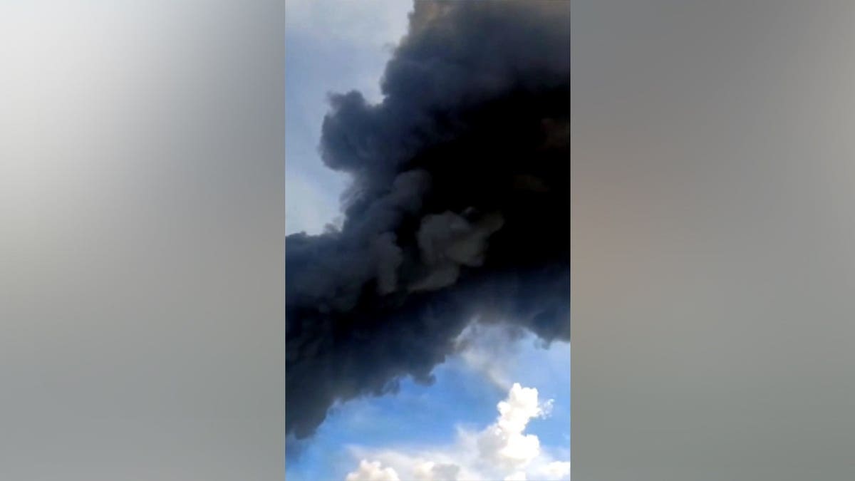black smoke rising in sky