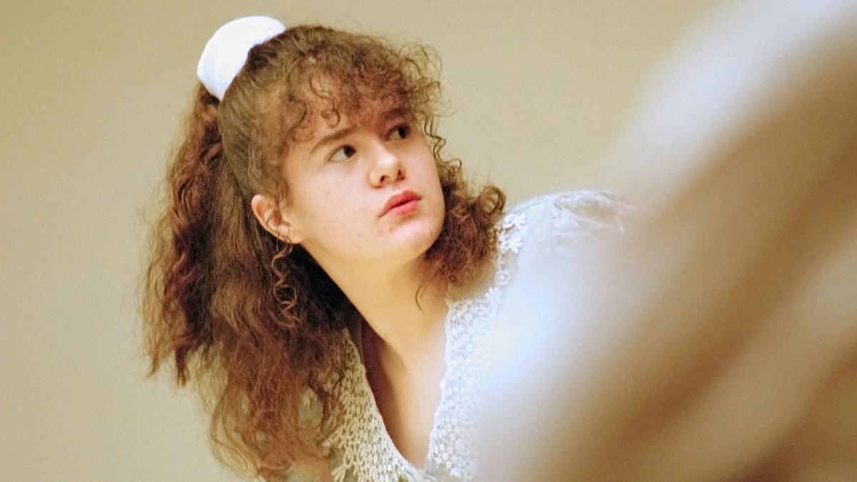 Christa Pike wearing white with curley red hair at trial in 1996