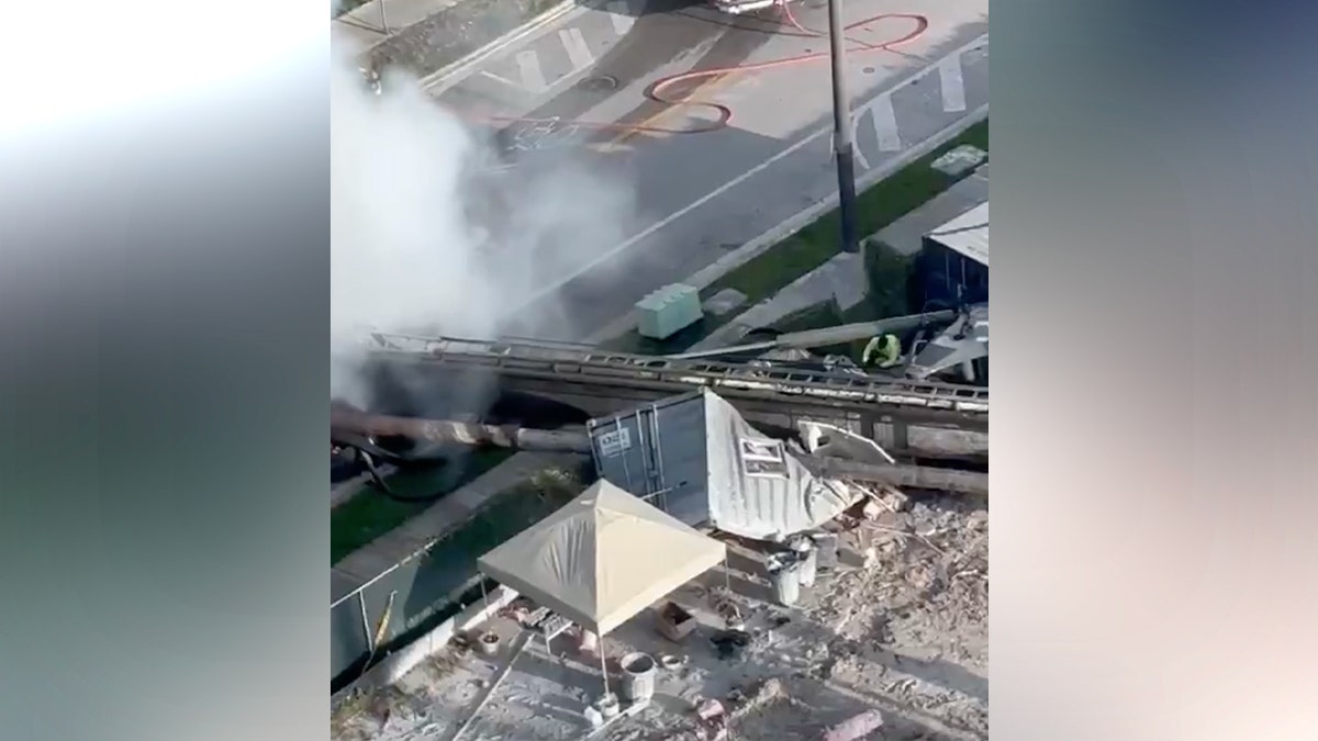 Four people were taken to the hospital Monday after a construction rig toppled onto three vehicles and a construction container in Miami, trapping two workers and igniting a vehicle fire, authorities said.