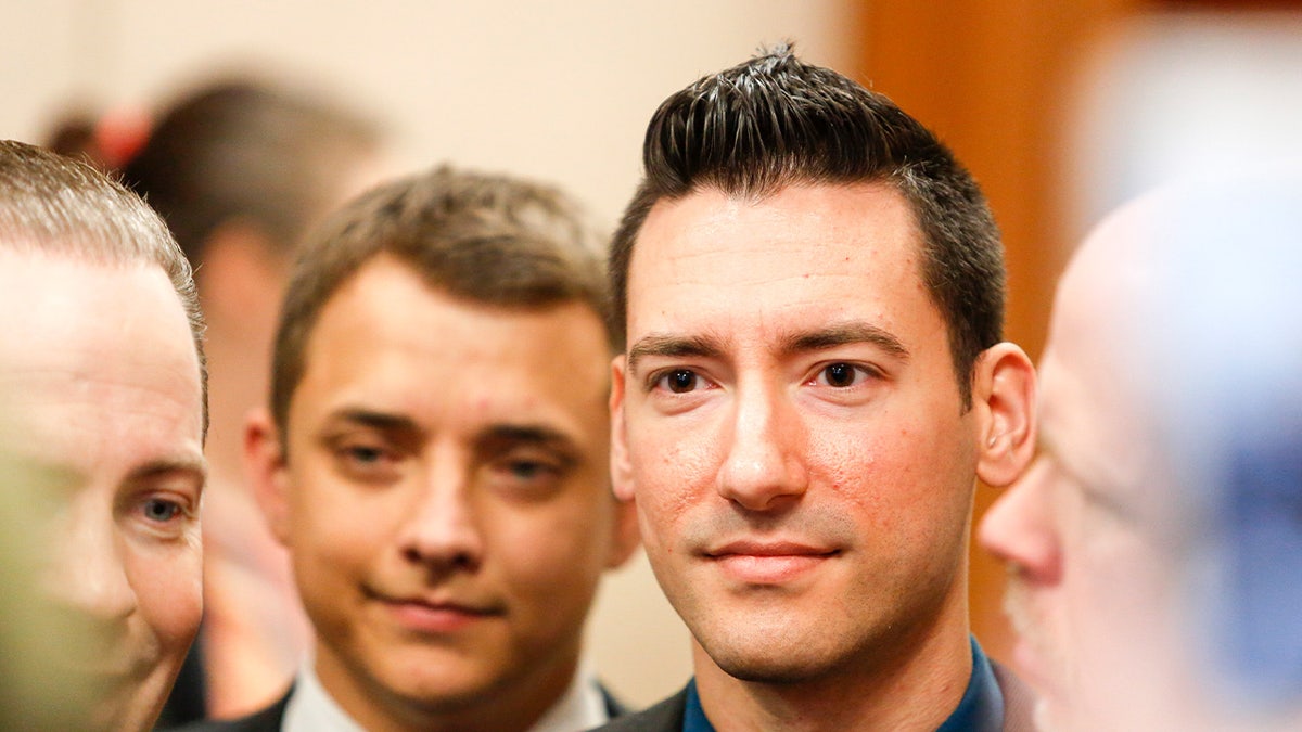David Daleiden standing in a courtroom and smiling.