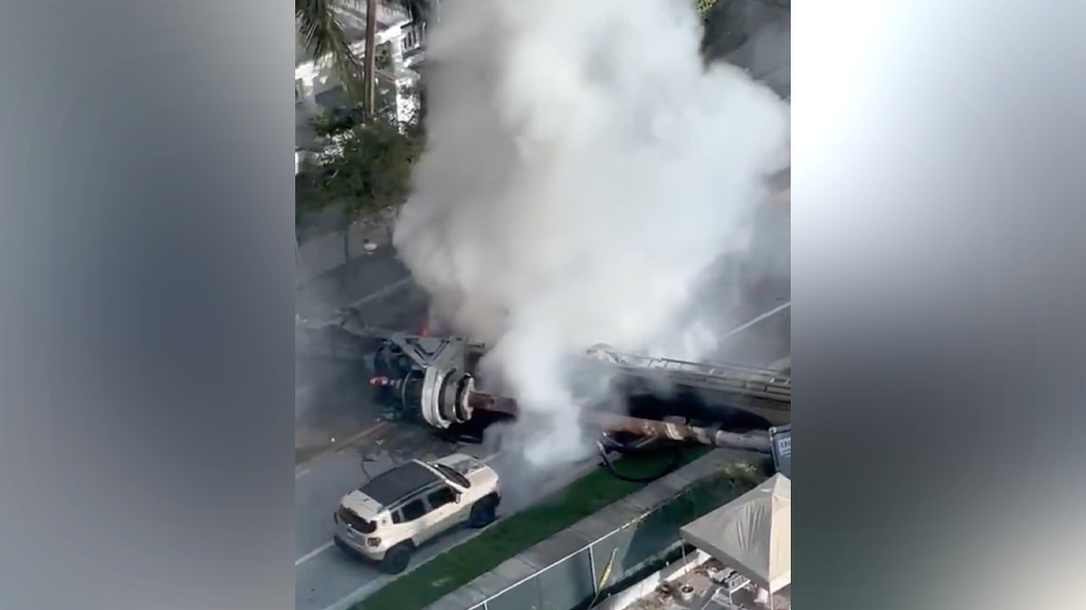 Four people were taken to the hospital Monday after a construction rig toppled onto three vehicles and a construction container in Miami, trapping two workers and igniting a vehicle fire, authorities said.